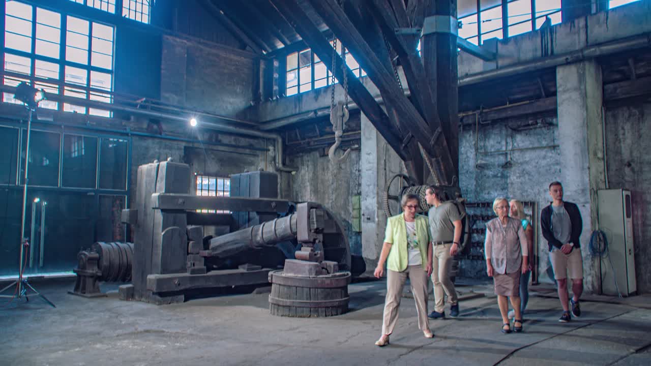Steel factory heavy machinery. Guided tour group visit. Tilt down