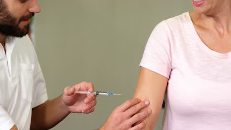 terapeuta que inyecta a una paciente femenina