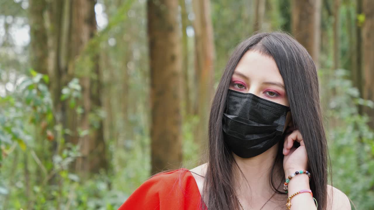 bastante joven latina, mujer morena tomando su mascarilla médica negra