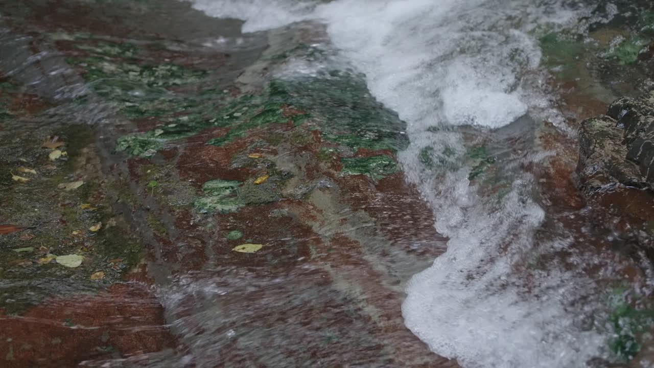 Acqua che scorre su rocce in un ruscello