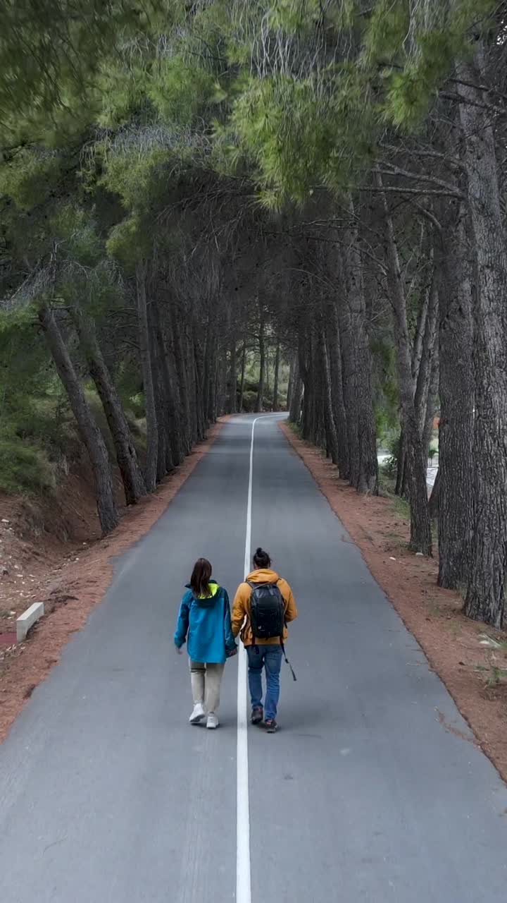 Pasangan Berjalan di Jalan Berjejer Pohon