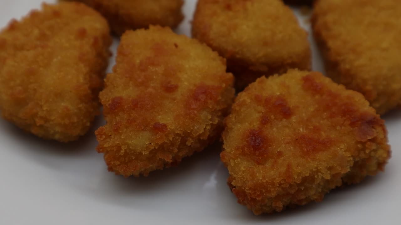 nuggets de pollo crujientes al horno en un plato blanco