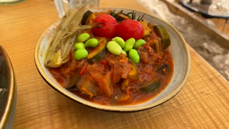 Sabroso-Plato-De-Ratatouille-Francés-Con-Verduras-Guisadas,-Tomates-Cherry-Y-Frijoles-Edamame-Japoneses-En-Un-Tazón,-Toma-De-4k