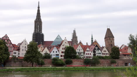 Church-steeple,-row-houses-in-Ulm,-Germany,-across-Danube-River