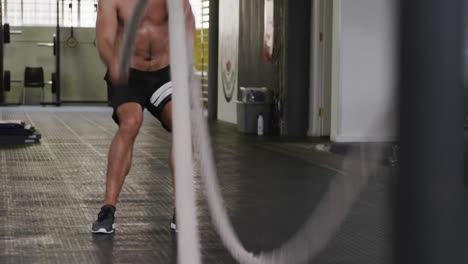 Front-view-of-an-athletic-Caucasian-man-working-out-with-battle-ropes