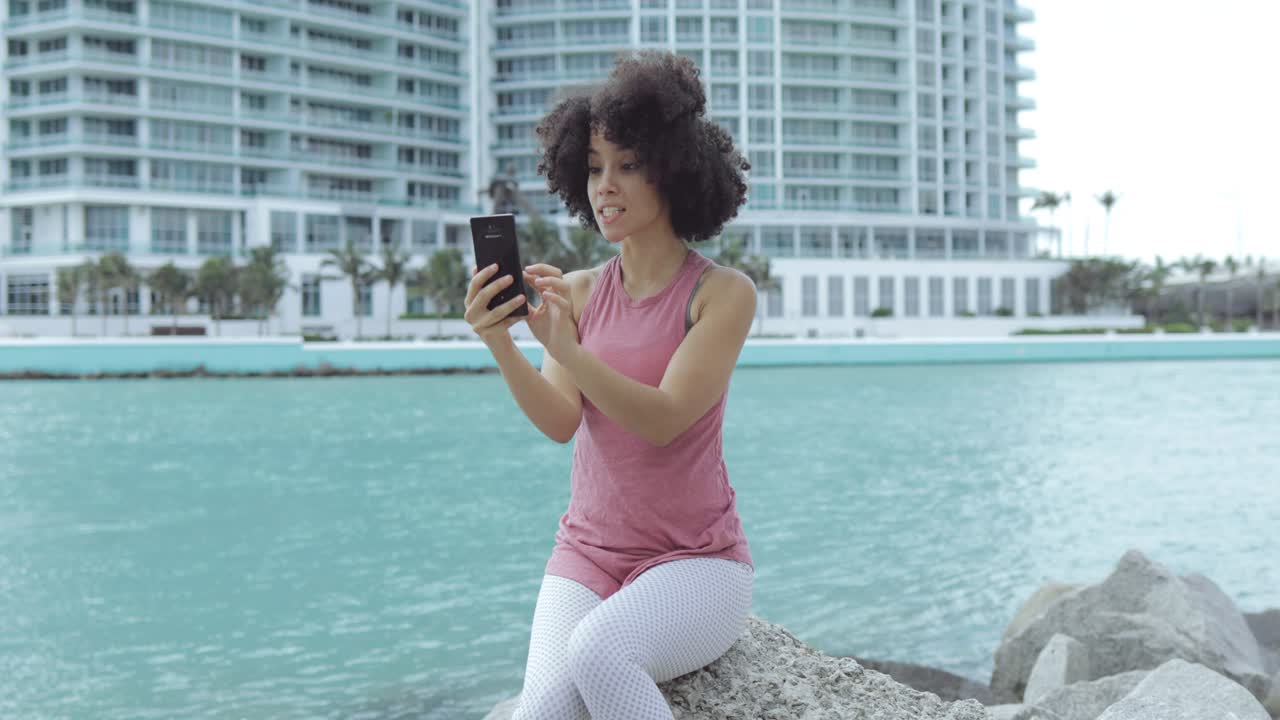 chica negra casual tomando selfie en el terraplén
