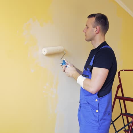 young worker painting wall in room. offering professional painting services