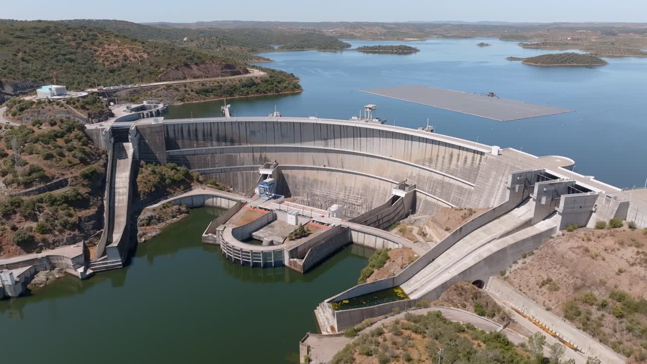 Circling above the expansive Alqueva Dam walls and solar farm floating on the lake