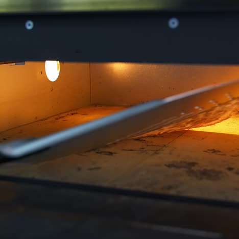 pizza in oven. baking pizza. the chef is turning hot pizza with a spatula in a stove. process of cooking pizza in pizzeria. tasty cookery