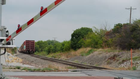 The-barriers-of-level-crossing-open-after-train-passes-and-cars-begin-to-cross-in-Fort-Worth-Texas,-USA