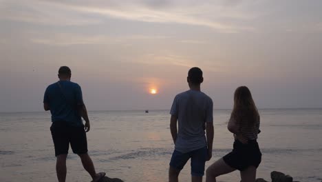 un grupo de amigos admiran la puesta de sol en cartagena, colombia, américa del sur sobre el agua del mar.