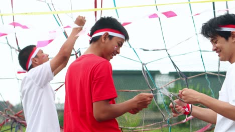 young indonesian men cheerfully preparing decorations for independence day celebrations