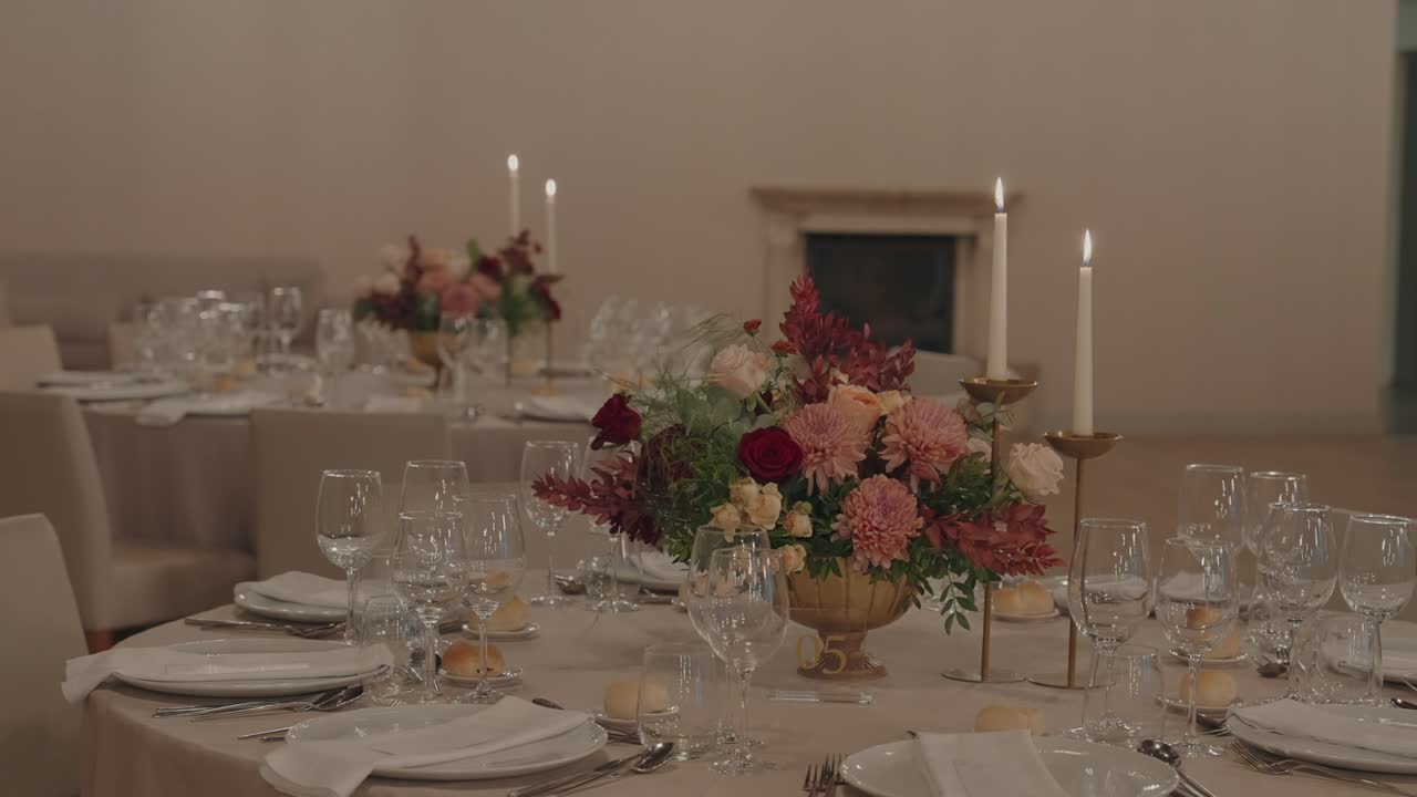 Banquet table set with flowers glassware plates and candlelight
