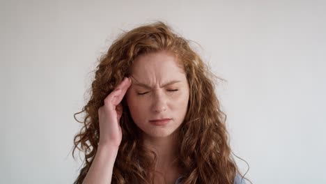 studio shot of young caucasian woman having a headache