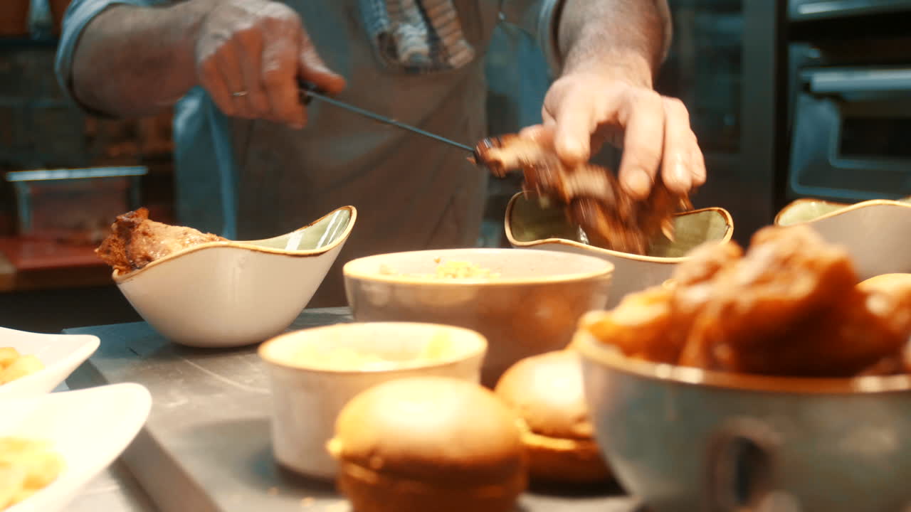 요리사는 칼을 사용하여 맛있는 갈비를 그릇에 넣습니다.
