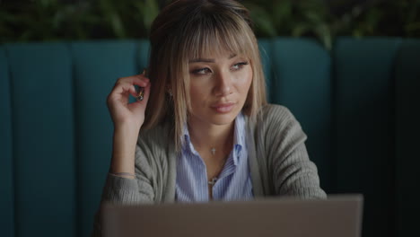 mujer asiática preocupada que trabaja en una computadora portátil mirando hacia otro lado pensando resolviendo problemas mujer seria buscando inspiración tomando decisiones sintiendo falta de ideas