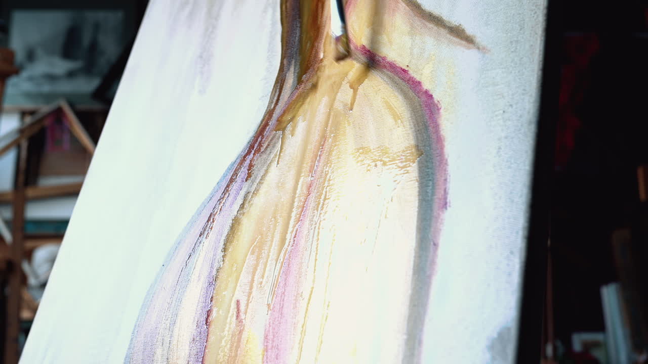 Close up of a woman painting on a canvas at an art gallery workshop