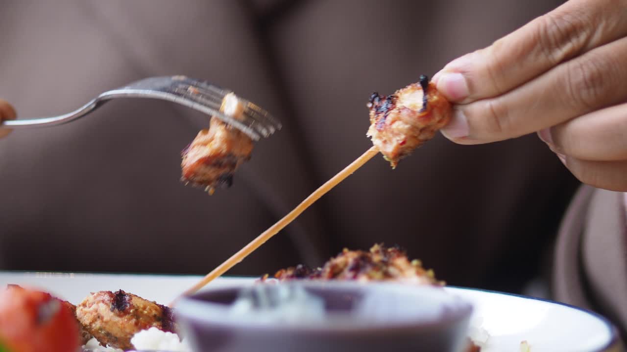 Mangiare spiedini di carne