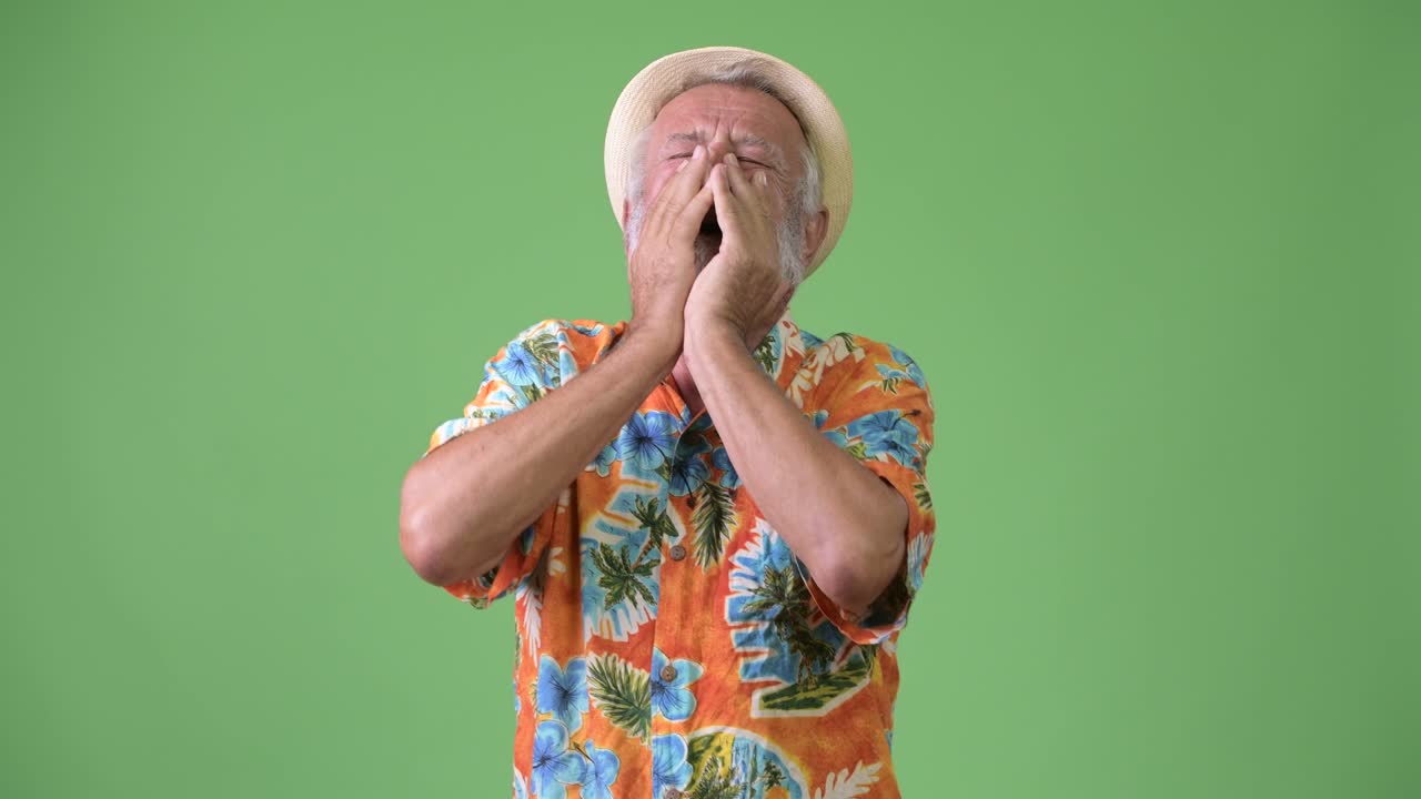 Bell'uomo anziano barbuto, turista, pronto per le vacanze su sfondo verde.