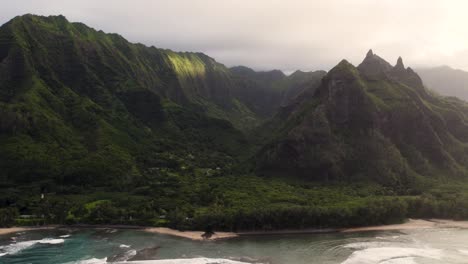 Antena-épica-Sobre-El-Paisaje-De-La-Costa-De-Hawaii-Del-Parque-Haena,-Vistas-Panorámicas-Del-Parque-Napali-Con-Picos-Verdes-De-La-Selva-Tropical-Cubiertos-Por-Nubes-De-Lluvia