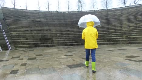 Kind-Mit-Regenschirm-In-Nasser-Straße