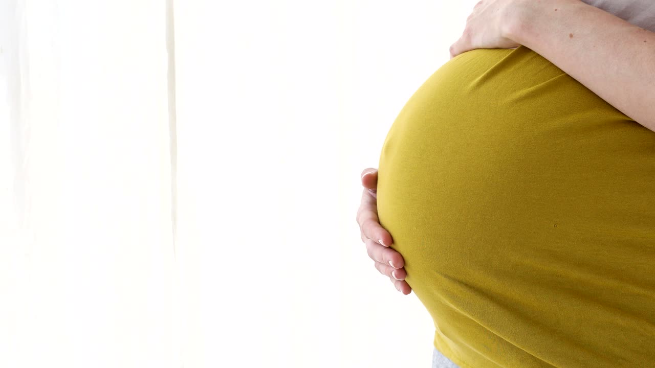 배에 손을 고 있는 임신한 여성