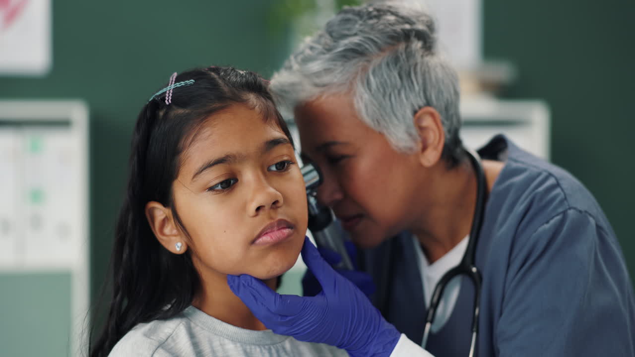 Medico che esamina l'orecchio di un bambino con l'otoscopio