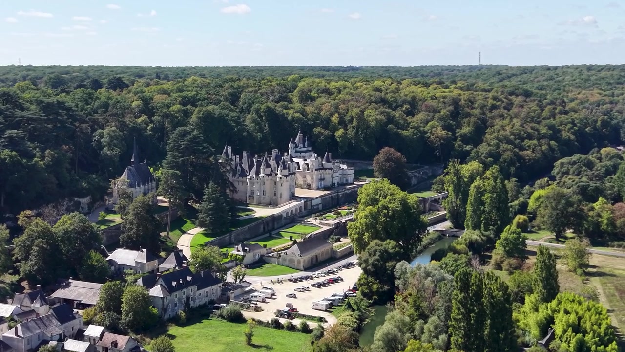 Riprese aeree mostrano il Château d'Ussé circondato da boschi, giardini curati, case del villaggio, strade e spazi verdi aperti nella Valle della Loira
