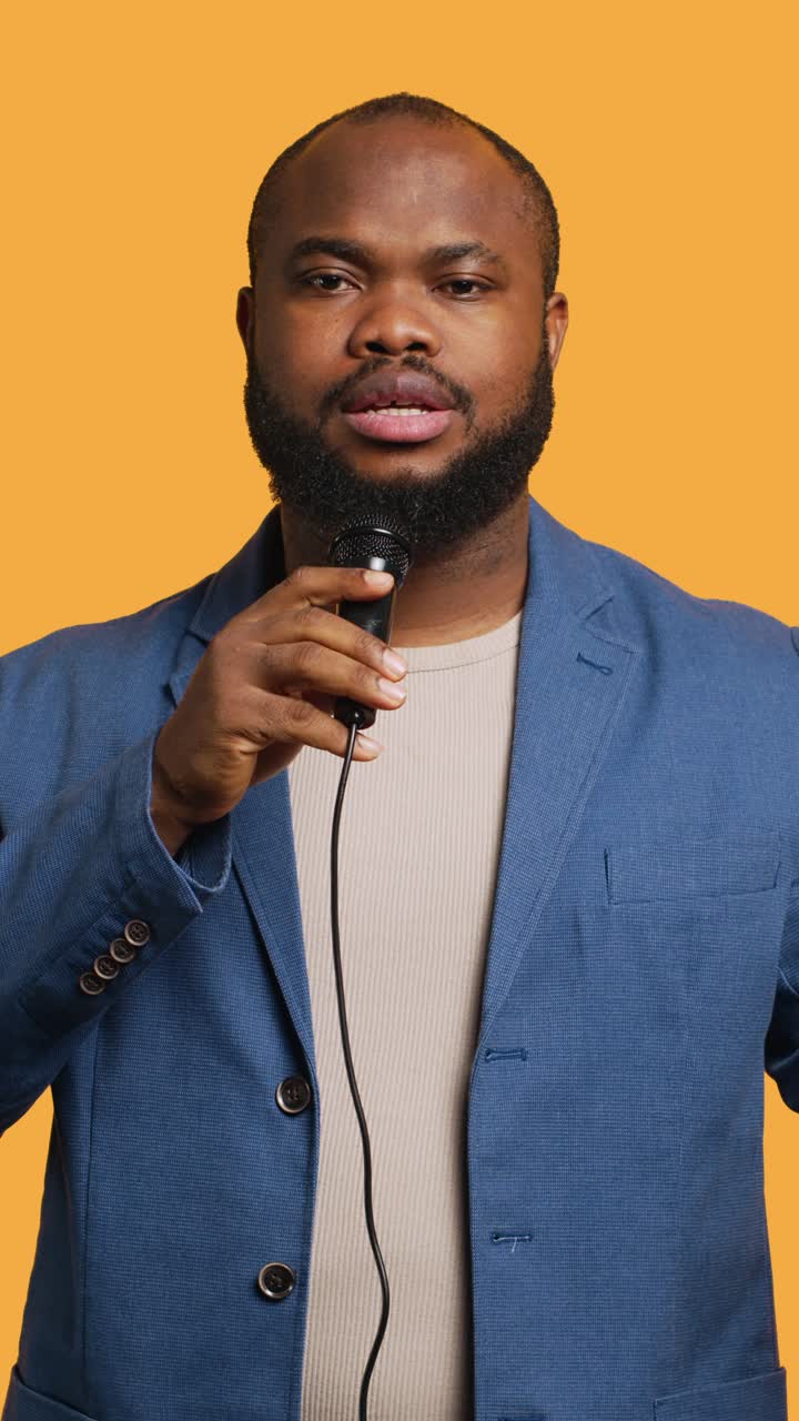 Vertical video Lecturer holding monologue using microphone, studio background
