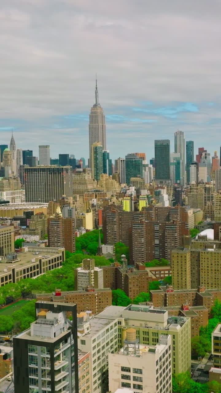 Diverse buildings in New York panorama. City combining usual structures with skyscrapers and green parks. Top view. Vertical video
