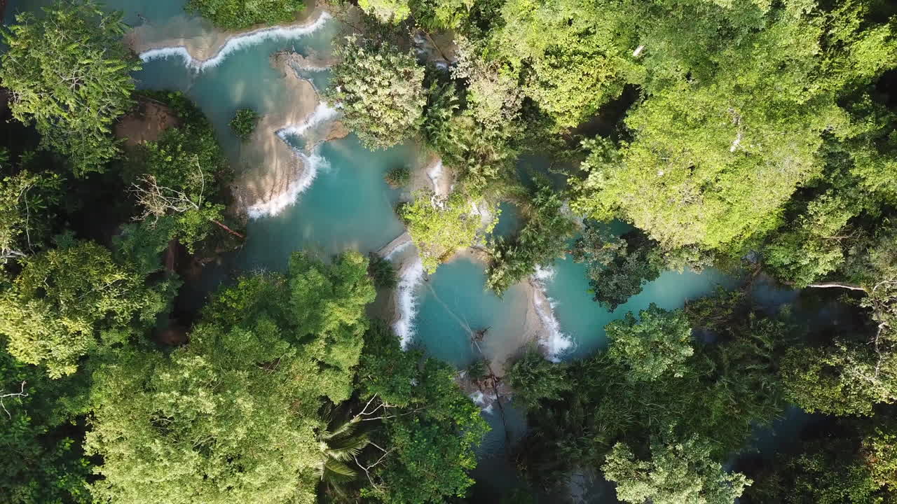 Piscine naturali nascoste con acqua turchese nel profondo della foresta pluviale, vista aerea ascendente a volo d'uccello