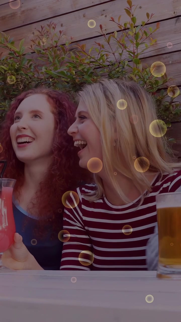 Video verticale: Gruppo al bar che reagisce a un segnale fuori campo, alzando birra e una bevanda rosa, con bollicine che appaiono.