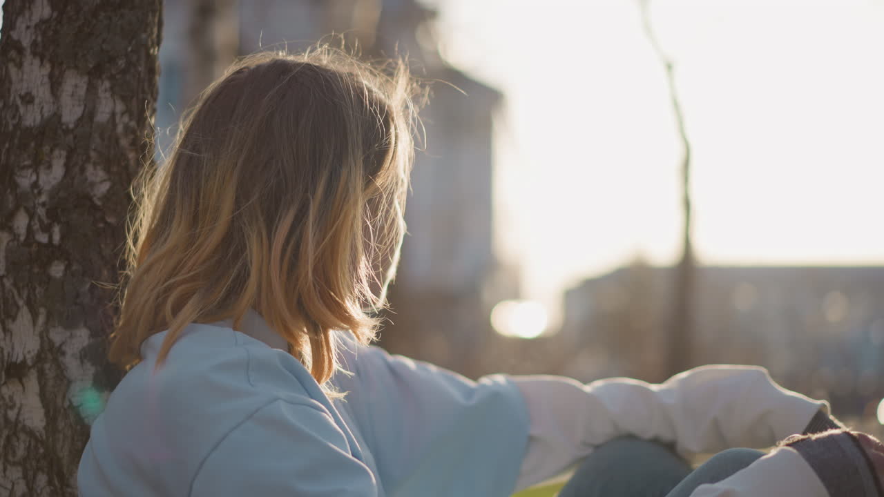 나뭇가지 아래에서 휴식을 취하는 조용하고 외로운 모습, 무성한 덮개 잎 아래에 차분하게 앉아 있는 평화로운 개인, 빽빽한 녹색 나뭇잎 아래에서 평화롭게 혼자 앉아 있는 고요한 사람