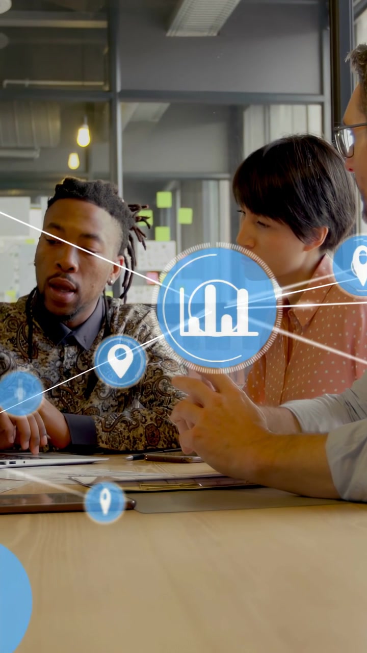 Vertical video: 3-person team tapping laptop sparking data nodes forming charts for business