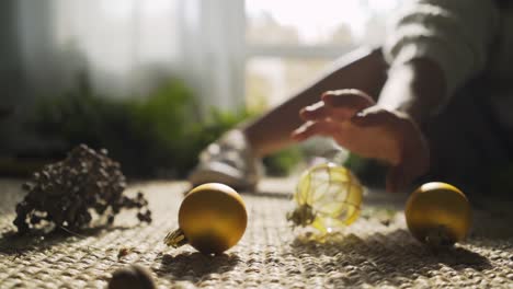 woman takes toy ball making festive wreath for christmas