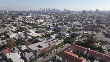 East-Hollywood-and-Downtown-Los-Angeles-neighborhood-during-the-day,-aerial-rising-view