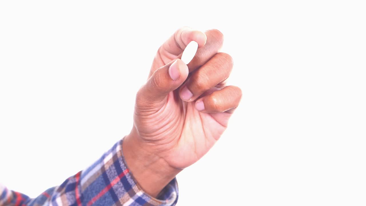 mano con una píldora blanca