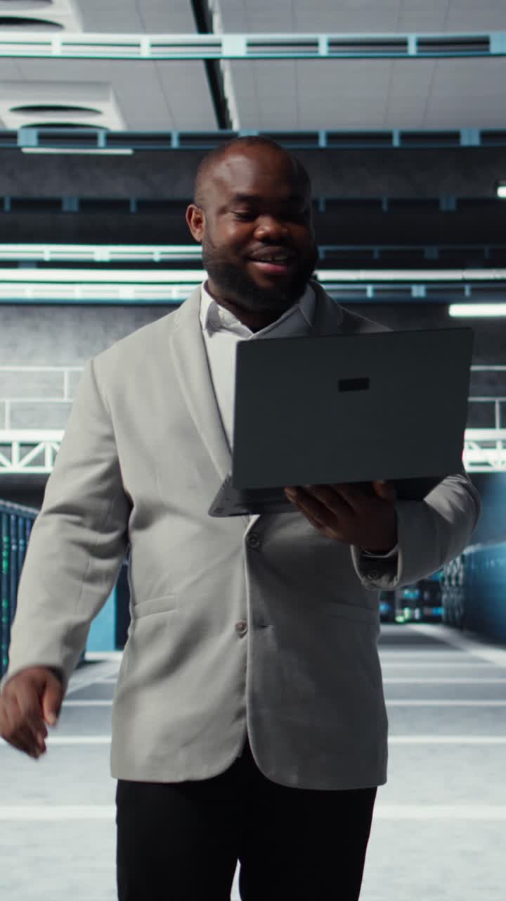 Video verticale Ingegnere sorridente della sala server che esegue manutenzione sui rack dei server
