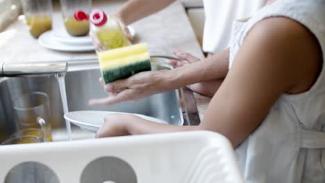 Girl-and-her-mom-washing-dish-together