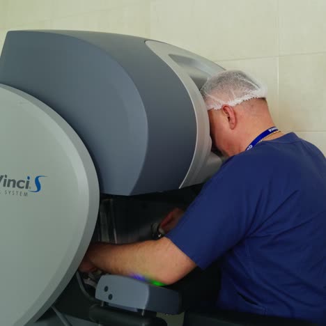 surgeon operating medical robotic surgery machine. manual control by minimally invasive surgical system. da vinci surgery