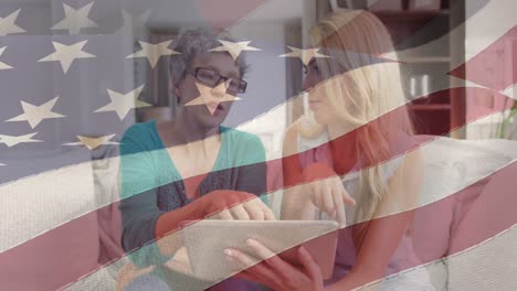 Animation-of-american-flag-over-mother-and-daughter-using-tablet-at-home