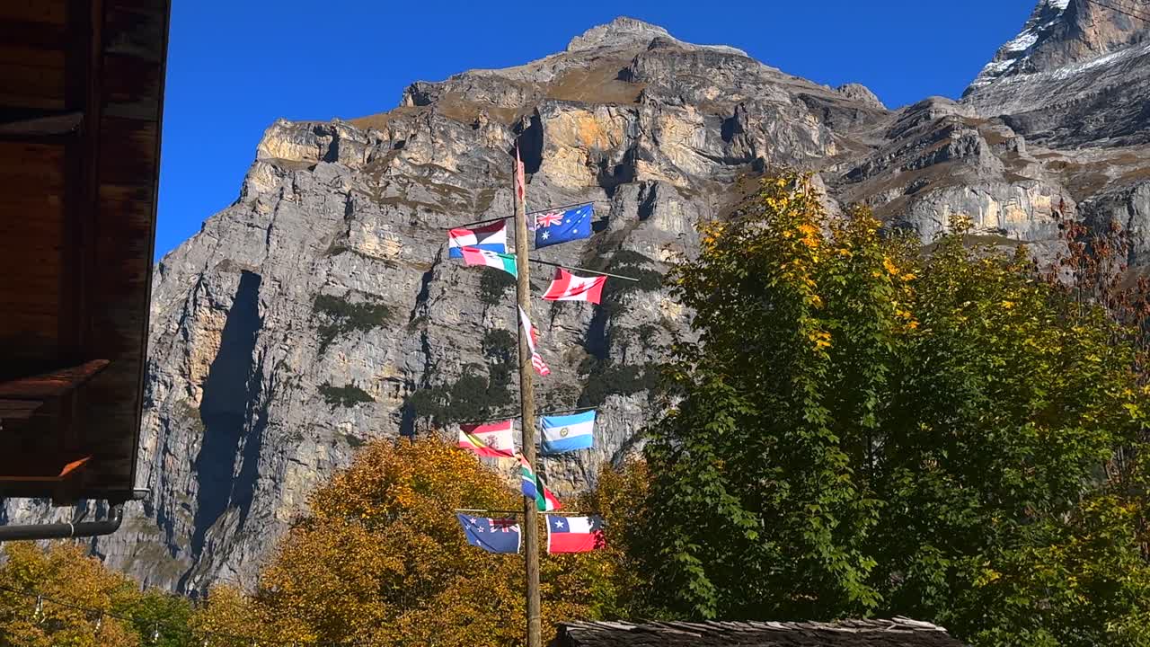 Allmendhubel Mountain World flags Swiss Alps Murren Mürren Gimmelwald Lauterbrunnen Valley Switzerland Schweiz Autumn Fall alpine village Chalet lodge sunny blue sky Jungfrau region Schilthorn Piz Glo