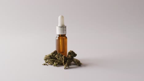 Video-of-marijuana-buds-and-bottle-of-cbd-extract-on-white-background