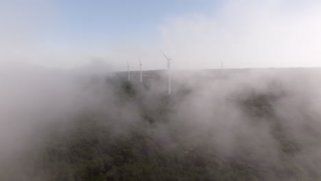 wind farm in misty mountains