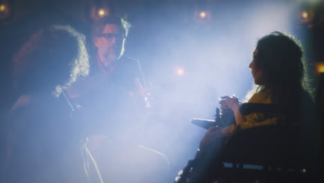 helping a person in a wheelchair at a performance