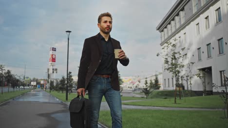 businessman walking with coffee and laptop bag