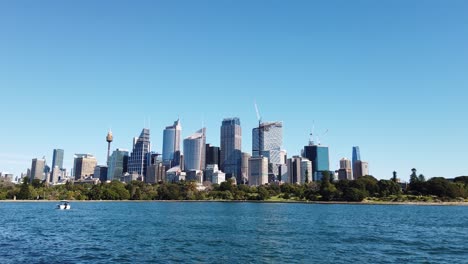 view of cbd high-rise buildings of sydney city across the waters from the botanical gardens in nsw, australia