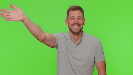 Bearded-man-appear-from-below-waving-hello-with-his-palm,-greeting-with-hospitable-friendly-smile