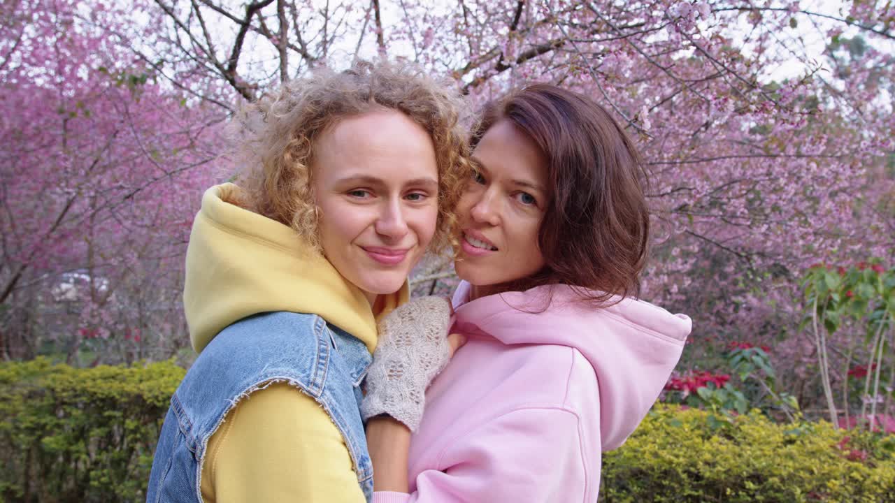 Two Women Hugging in a Cherry Blossom Park