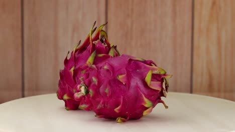 dragon fruits rotating on a wooden surface